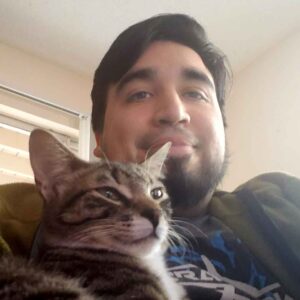 Photo of Christopher with his tabby cat, Debug